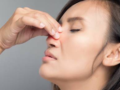 The asian woman hurts her nose because she has cold.